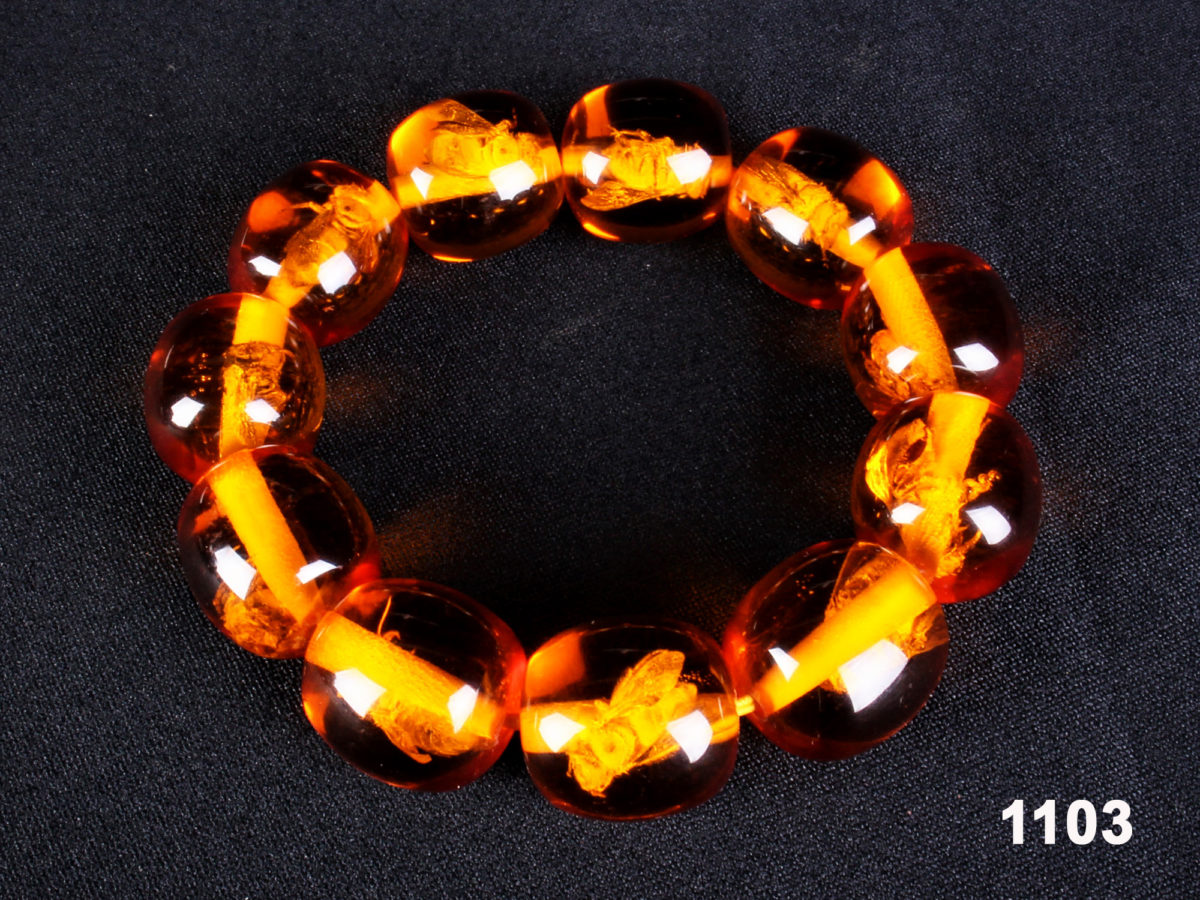 Modern amber colour elasticated bead bracelet with an insect in each bead from Antiques of Kingston