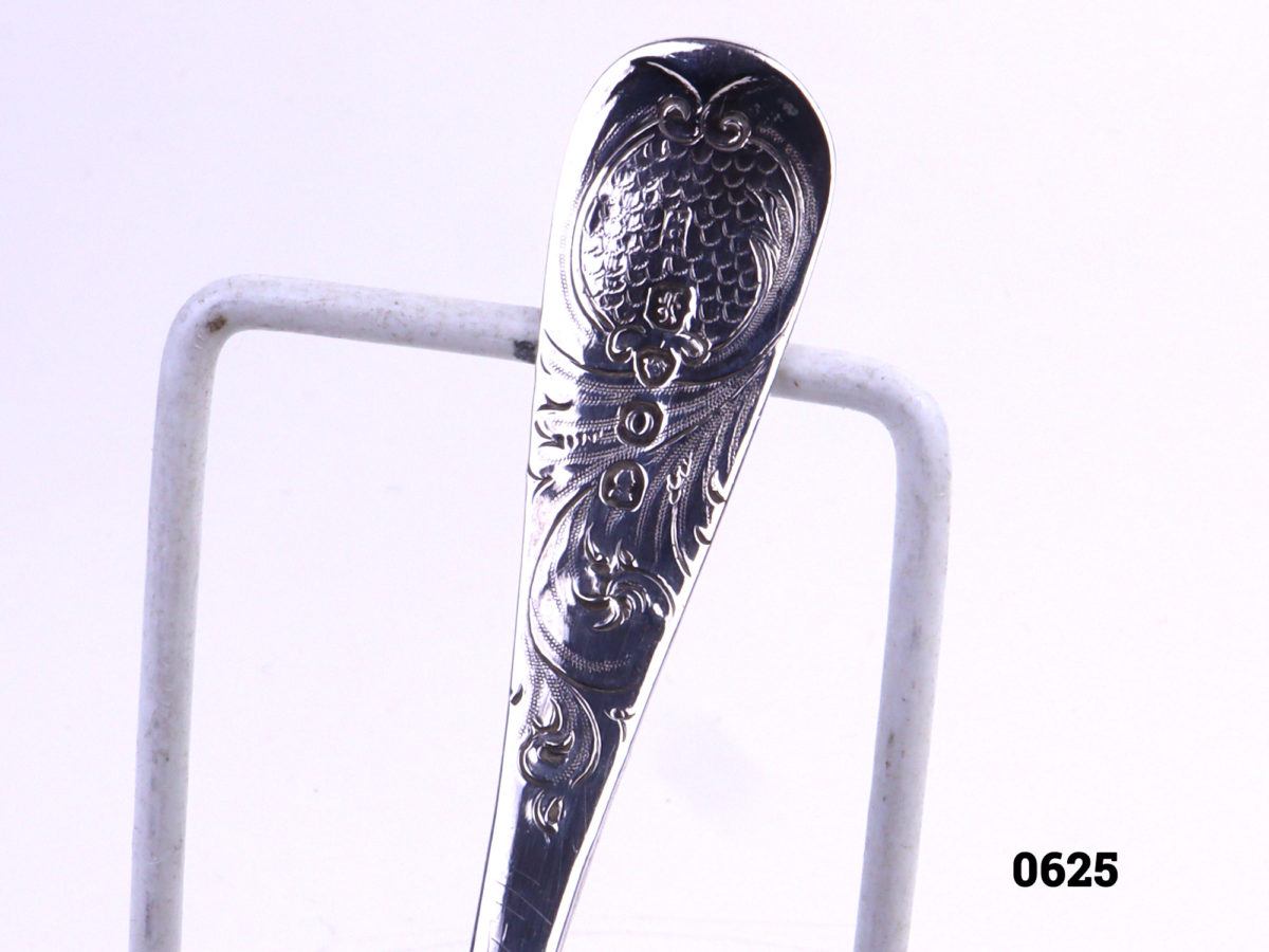 Antique silver strainer spoon with gilt bowl decorated with fruit Traditionally used to strain fruit especially berries c1829 London assayed Bowl measures 43mm in diameter and 13mm deep Close up photo of the hallmark on the back handle of spoon