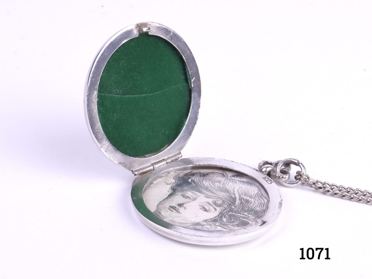 Enamelled locket on chain Art Nouveau style sterling silver locket with enamelled iris flower to the front on a white metal chain Pendant measures 33mm in diameter and weighs 13.1g Photo of open locket