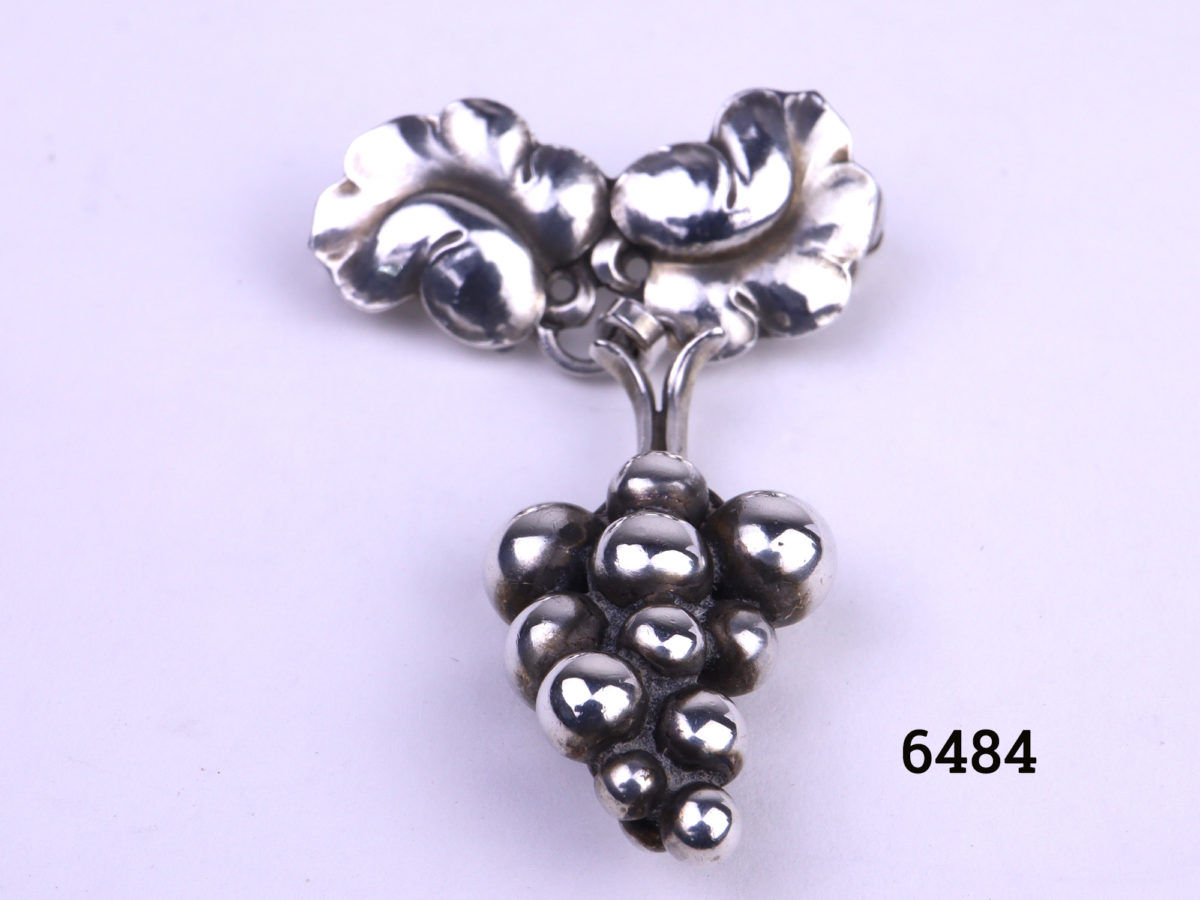 Georg Jensen Arts & Crafts sterling silver brooch in the form of a bunch of grapes hanging loosely from the vine leaves Close up photo of front of brooch