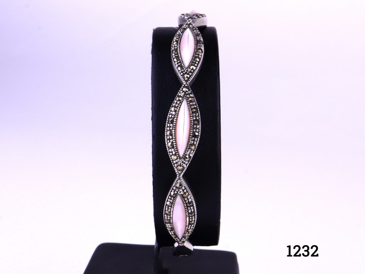 925 Sterling silver bracelet with marcasite and pale iridescent pink stones Inside measurement 58mm by 54mm Main photo showing bejewelled side of bracelet on display stand