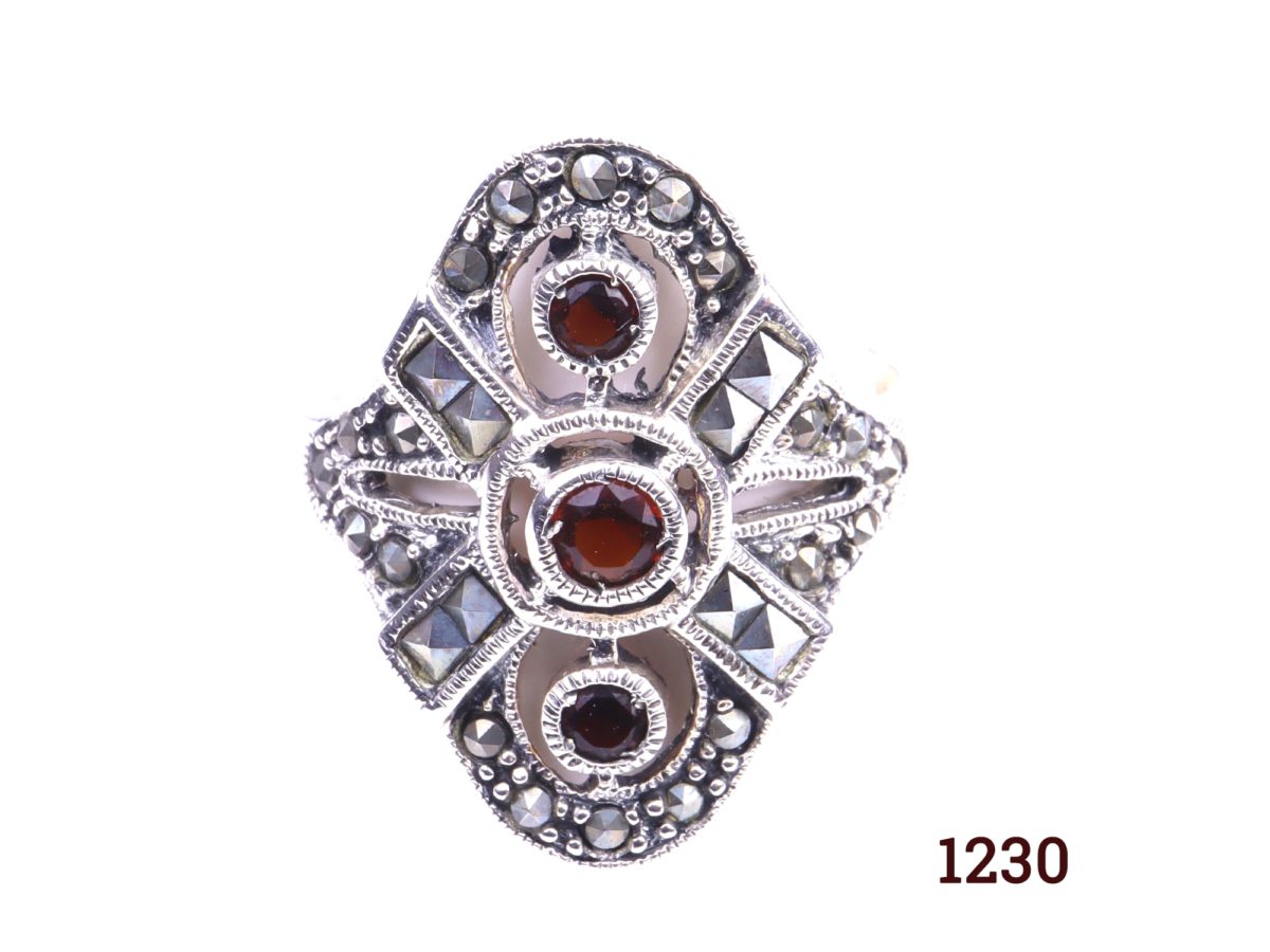 Silver and garnet ring 925 Sterling silver ring set with three garnets and marcasite in an Art Deco style Size R / 8.5 Ring front measures 25mm by 22mm Close up of front of ring