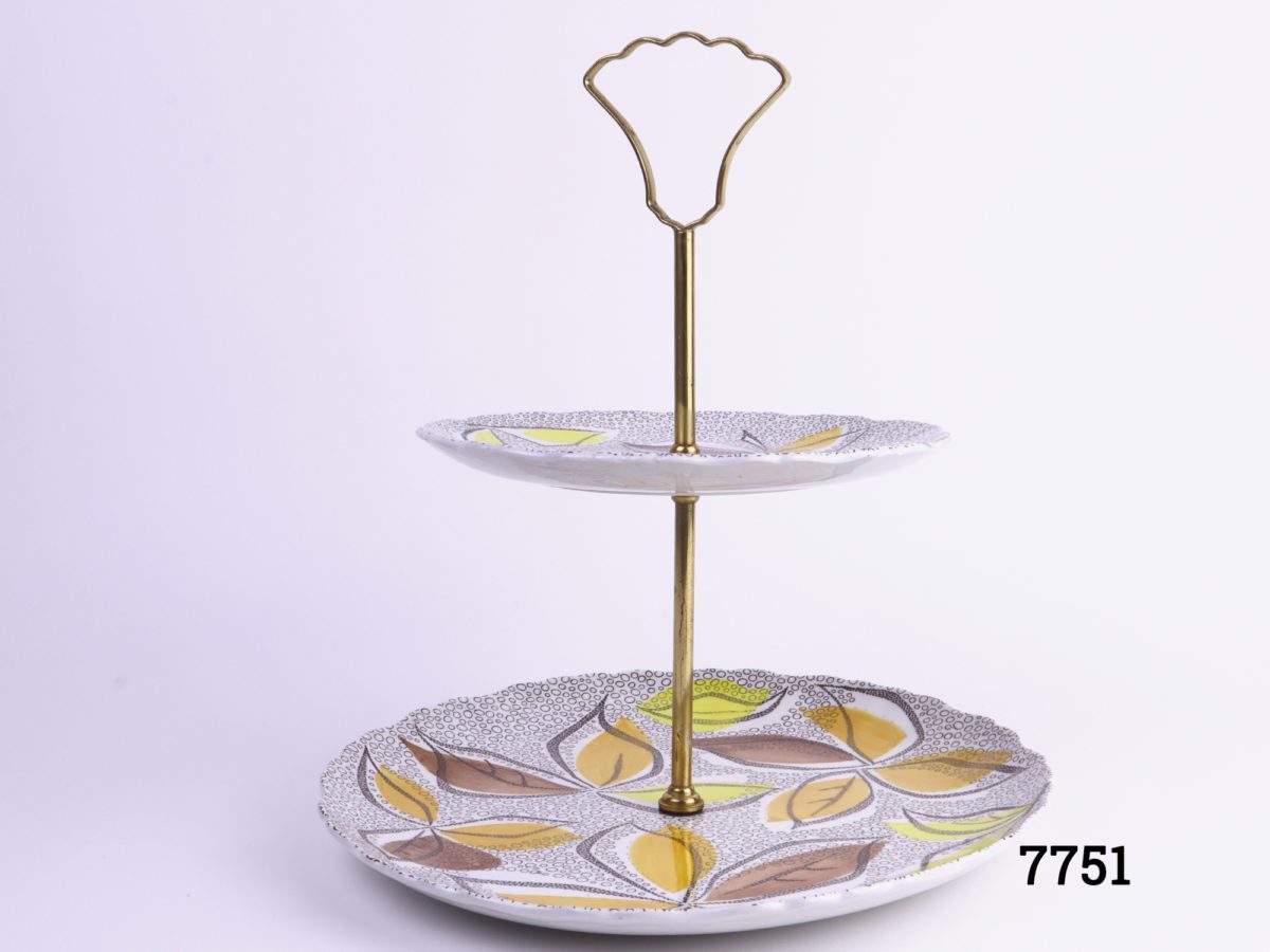 1960s two tier cake stand with gilt metal handle and rod Made at the Old Foley potteries by James Kent ltd England Acid & detergent proof colours Bottom plate measure 225mm in diameter & top measures 160mm in diameter Main photo showing whole cake stand from side on view
