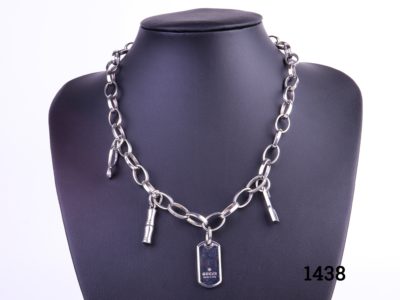 Solid 925 Sterling silver Gucci charm necklace with 4 charms including a Gucci dog tag. Necklace weighs 43.6g. Main photo of front of necklace showing all 4 charms on display stand.