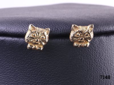 9 Carat gold cat stud earrings featuring the head of a cat with bow tie on each earring. Butterfly back fastening. Very small and fiddly Main photo showing close up of both cat stud earrings with visible details of cats features
