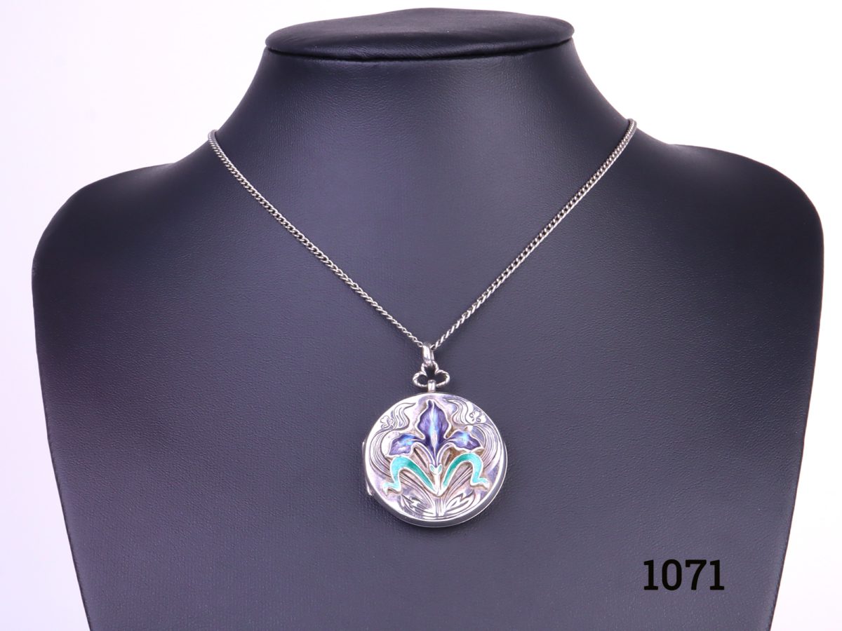 Enamelled locket on chain Art Nouveau style sterling silver locket with enamelled iris flower to the front on a white metal chain Pendant measures 33mm in diameter and weighs 13.1g Main photo of whole necklace on display stand
