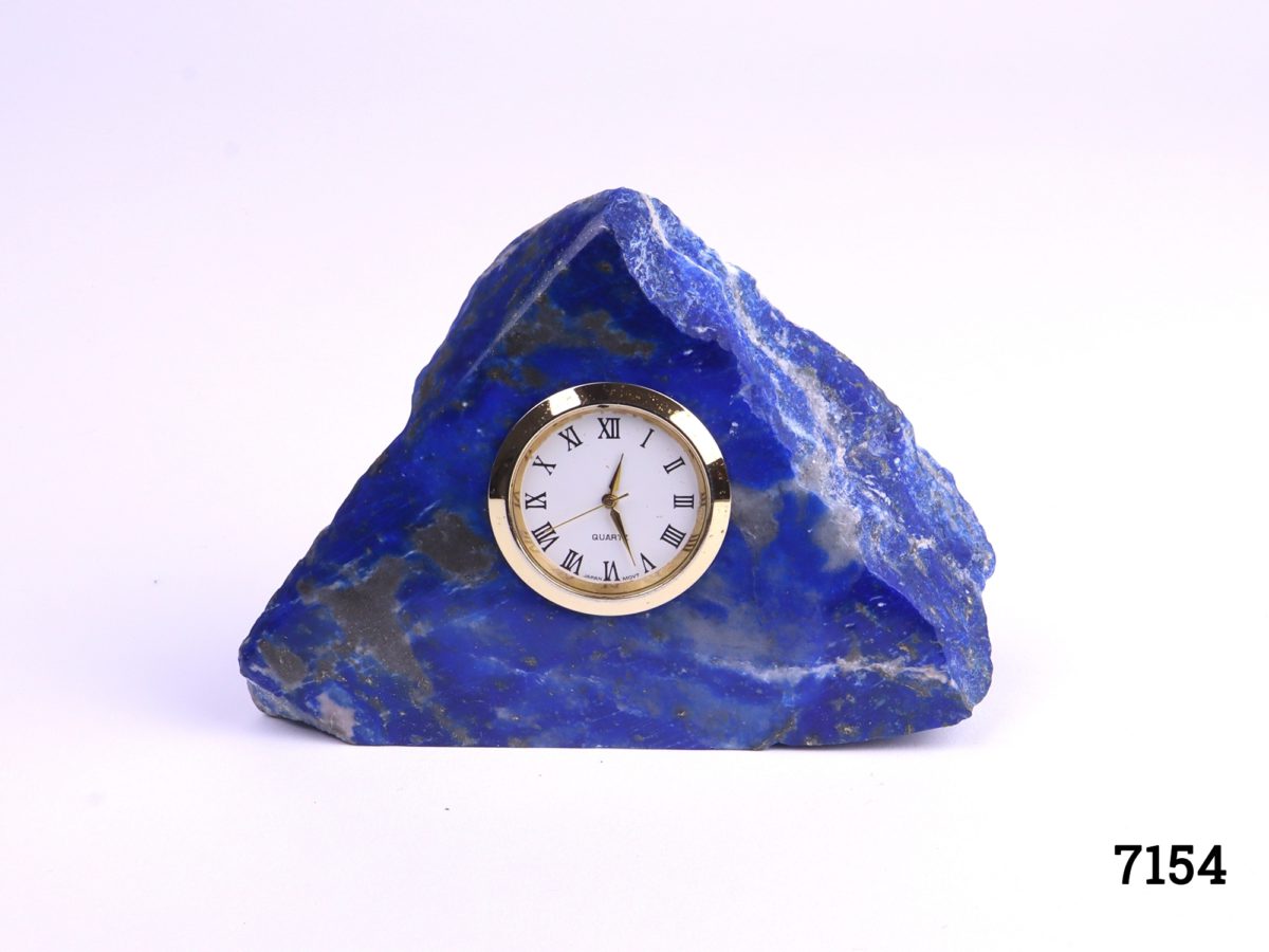 Lapis lazuli desk clock Modern battery operated clock set into a substantial piece of natural lapis lazuli stone In full working order Clock measures 35mm in diameter Photo of front of clock from a slightly raised angle