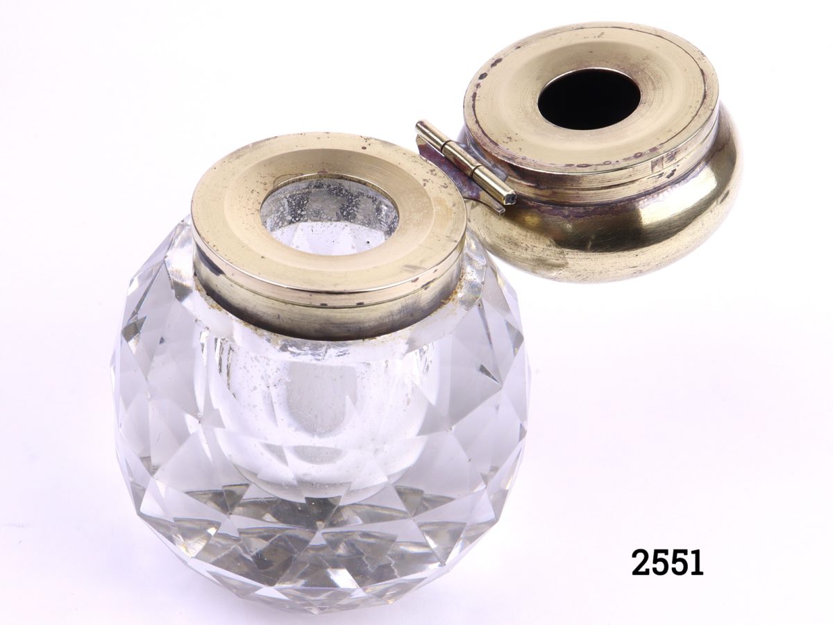 Pair of vintage cut glass inkwells with faceted sides and brass tops Close up photo of one inkwell with top open
