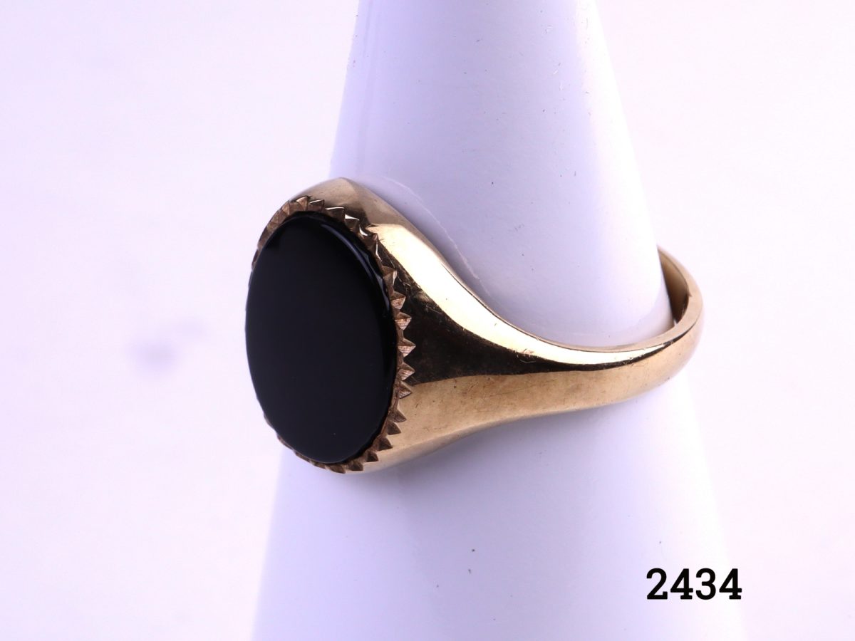 9ct Gold signet ring with black onyx c1988 Birmingham assayed fully hallmarked 375 and makers stamp AK Stone size 12mm by 10mm Size P / 7.5 Side view photo of ring on display stand