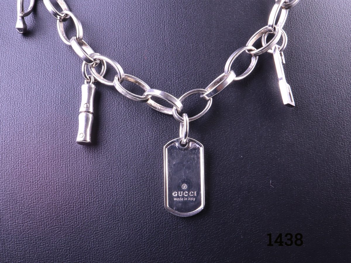 Solid 925 Sterling silver Gucci charm necklace with 4 charms including a Gucci dog tag Close up of the charms including Gucci dog tag showing designer logo