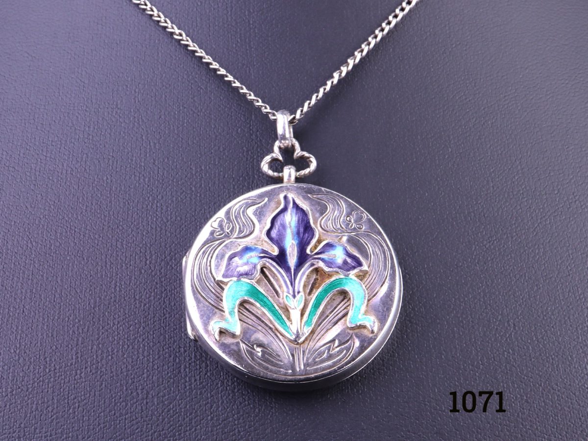 Enamelled locket on chain Art Nouveau style sterling silver locket with enamelled iris flower to the front on a white metal chain Pendant measures 33mm in diameter and weighs 13.1g Close up photo of the locket front