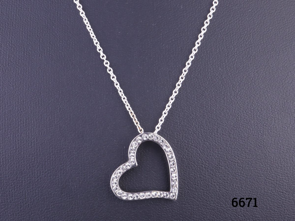 Silver heart pendant encrusted with cubic zirconia pieces on 925 sterling silver chain Pendant measures 22mm by 20mm and hangs slightly to the side Close up photo of heart pendant (front view)