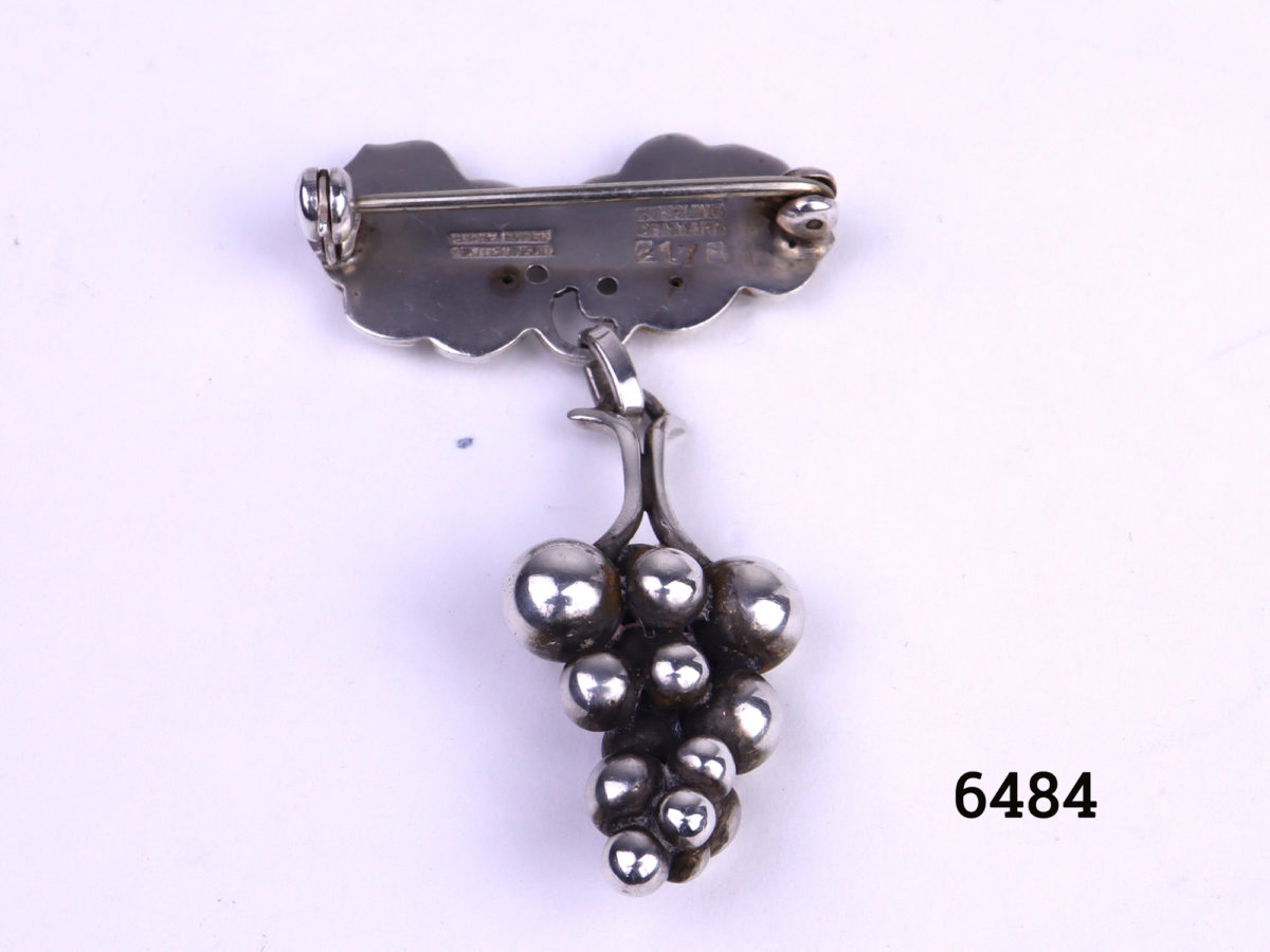 Georg Jensen Arts & Crafts sterling silver brooch in the form of a bunch of grapes hanging loosely from the vine leaves Image showing the back of the top leaf part of brooch and front of grapes bunch