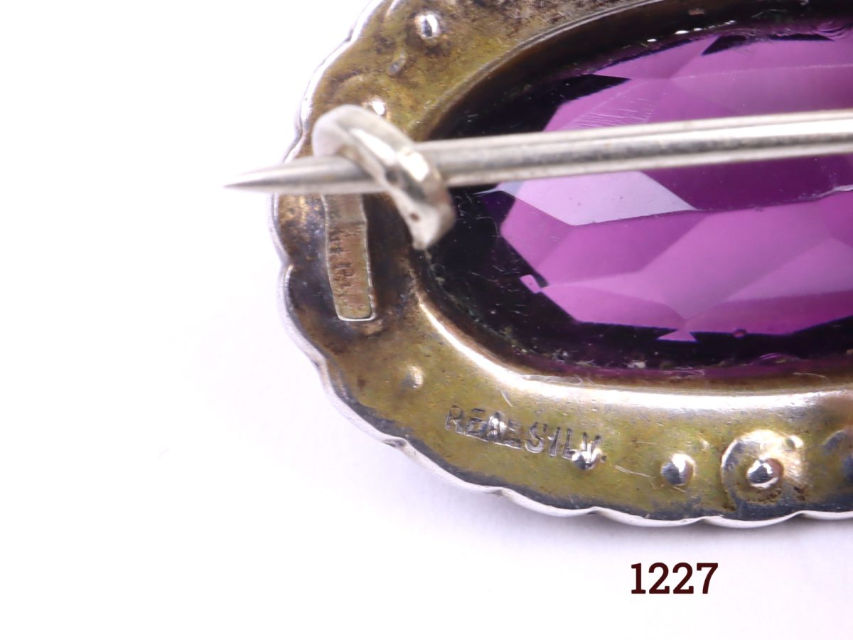 Edwardian silver petite oval brooch with amethyst coloured stone surrounded with seed pearls Close up photo of the hallmark