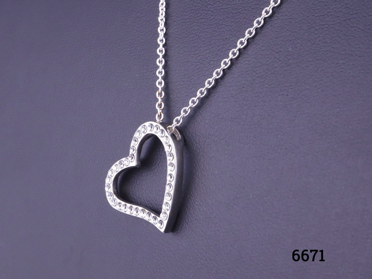 Silver heart pendant encrusted with cubic zirconia pieces on 925 sterling silver chain Pendant measures 22mm by 20mm and hangs slightly to the side Close up side view of heart pendant