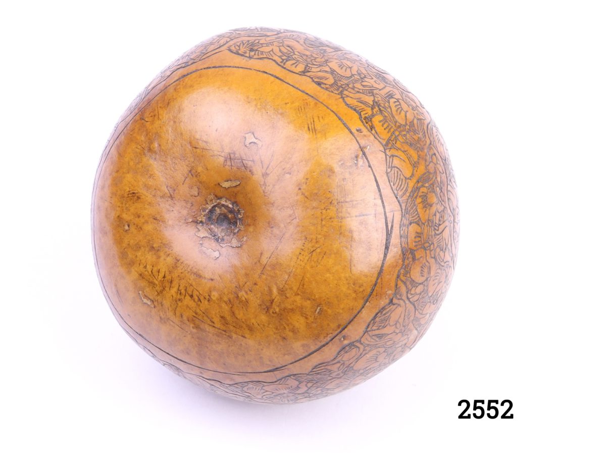 Vintage carved African gourd Intricately carved calabash gourd fruit depicting a rural farming scene Measures 65mm in diameter at base Photo of the base of fruit