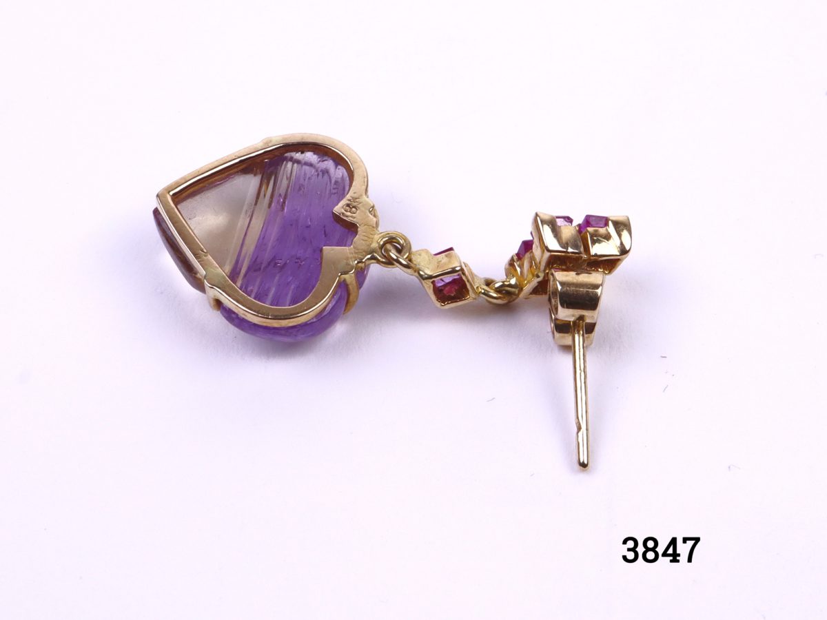 Ametrine and ruby earrings set in 18 carat gold (Ametrine is a variety of quartz with a mixture of amethyst and citrine) Drop length 35mm, 15mm at widest point and approximately 5mm in depth Close up photo of back of one earring showing 18kt gold hallmark