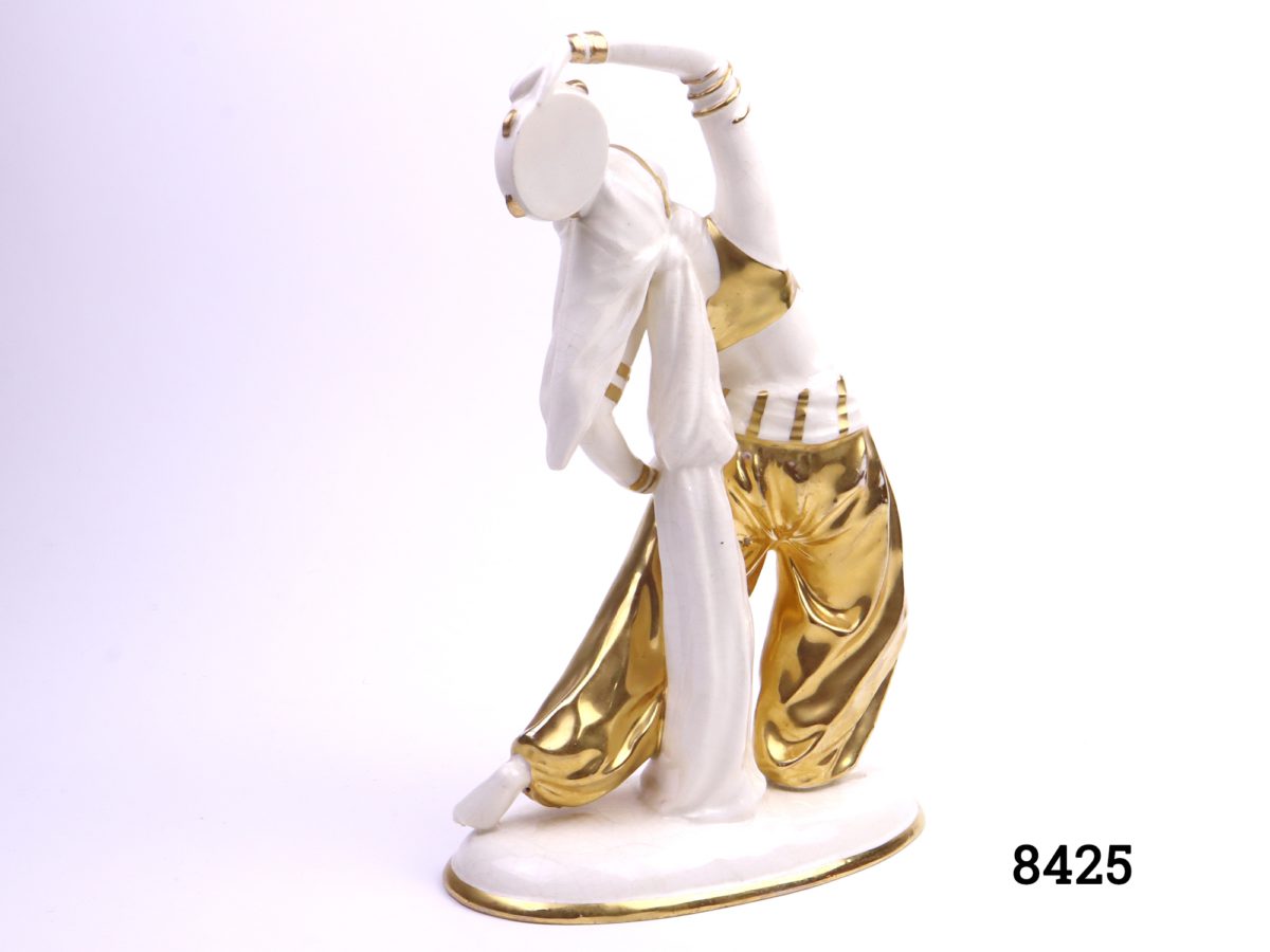 Art Deco porcelain figure of a Bedouin dancer with a tambourine in hand-painted gold hi-lights Made in Sitzendorf, Germany (Restoration work to tambourine, some crazing & cracking and wear to gold) Photo of back of figure