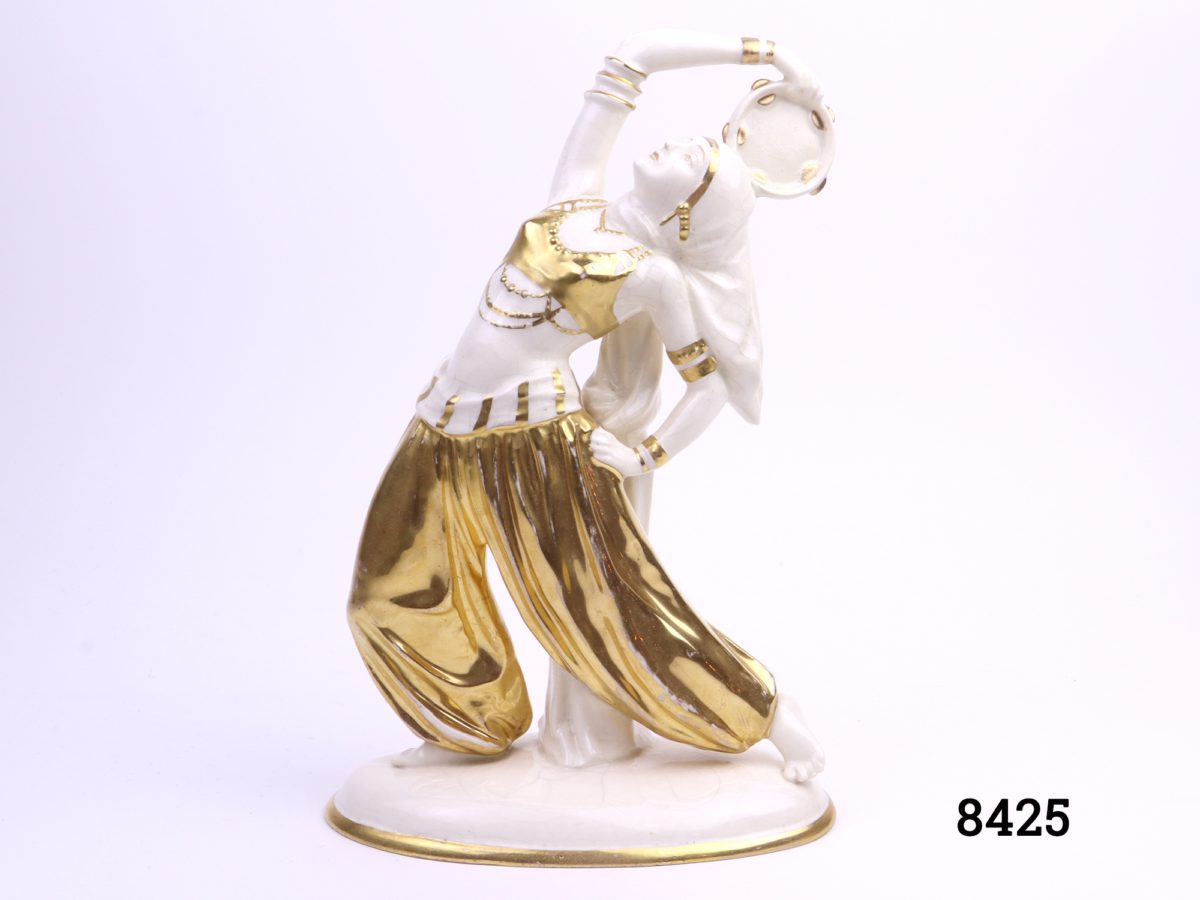 Art Deco porcelain figure of a Bedouin dancer with a tambourine in hand-painted gold hi-lights Made in Sitzendorf, Germany (Restoration work to tambourine, some crazing & cracking and wear to gold) Main photo showing front view of dancer