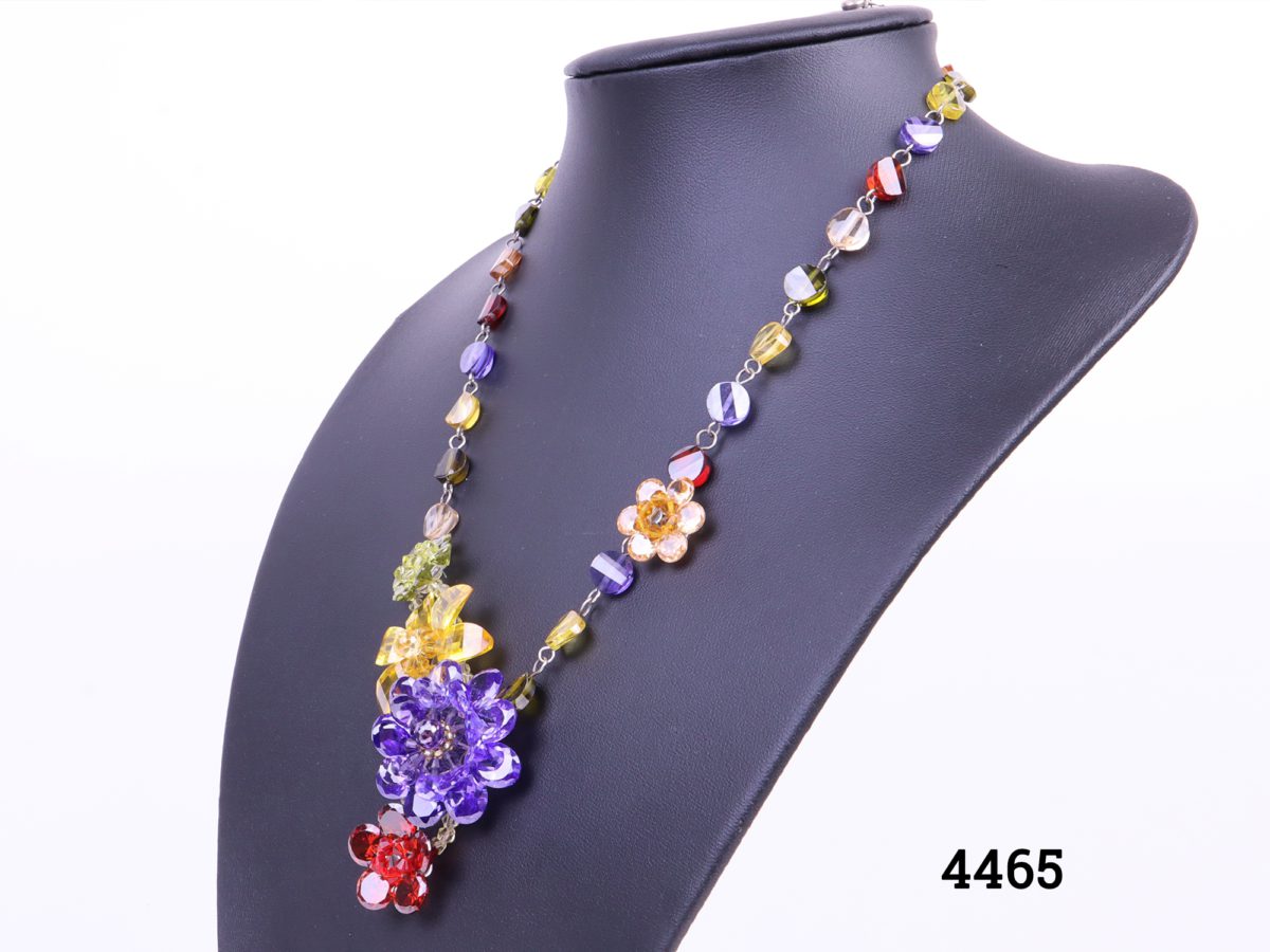 Colourful Butler and Wilson necklace with multi-coloured crystal flowers and beads Comes in original box Length adjustable from 420mm to 500mm Photo of necklace from a slight side angle on display stand