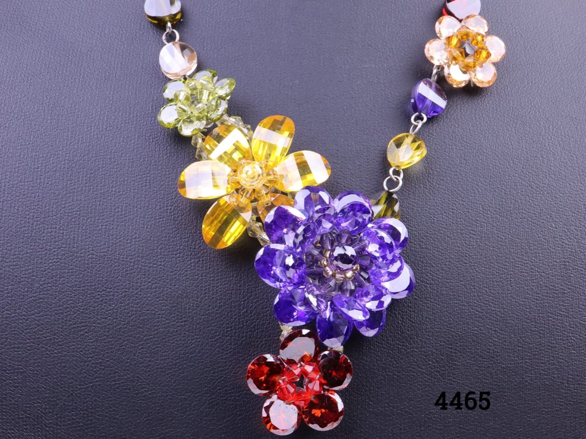 Colourful Butler and Wilson necklace with multi-coloured crystal flowers and beads Comes in original box Length adjustable from 420mm to 500mm Close up photo of the larger flowers on the end of the necklace