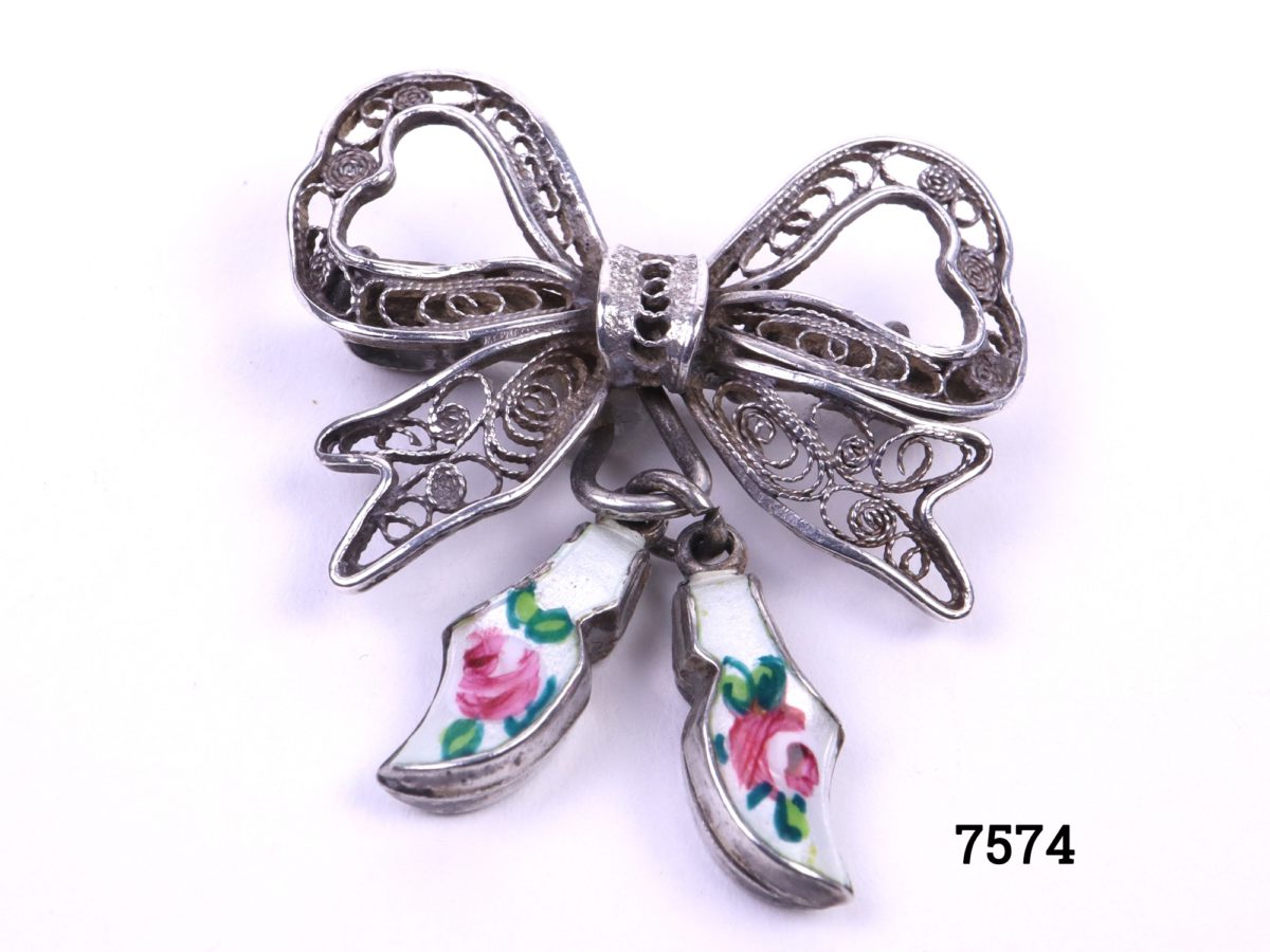 Sterling silver filigree bow brooch with attached pair of silver & enamel white clogs with hand-painted roses to each Main photo showing from of brooch with clogs hanging to the side showing enamelled roses