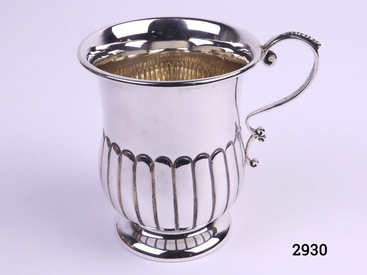 Small sterling silver mug with gilt interior c1920 Sheffield assayed made by James Deakin and Sons Photo looking down from slightly raised angle and with handle to the right and showing gilt interior