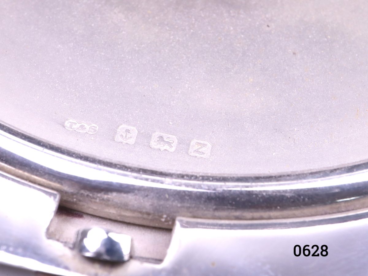 Sterling silver Art Deco compact with vacant cartouche for personalisation c1934 Birmingham assayed by Beddoes & Co Measures 90mm in diameter Close up photo of hallmark below the opening tab on outside of compact