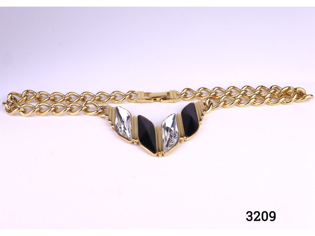 Vintage heavy gilt metal chain costume jewellery necklace with clear and black rhinestones to the front Photo of necklace on a flat surface showing the rhinestones to the front