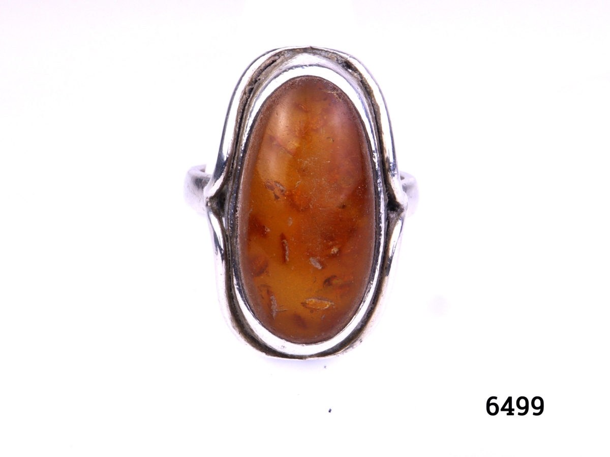925 Silver ring with Baltic amber stone. Hallmarked on outer band of ring. Made in Gdansk Poland. Size O.5 / 7.5. Ring front measures 30mm x 17mm. Main photo showing frontage of ring.