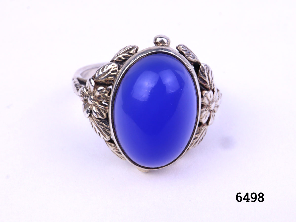 Arts & Crafts ring by Bernard Instone. Hallmarked silver ring set with bright sea blue oval chalcedony stone to centre and floral motifs to the shoulder either side. Size N / 6.5 Close up photo of the front of ring
