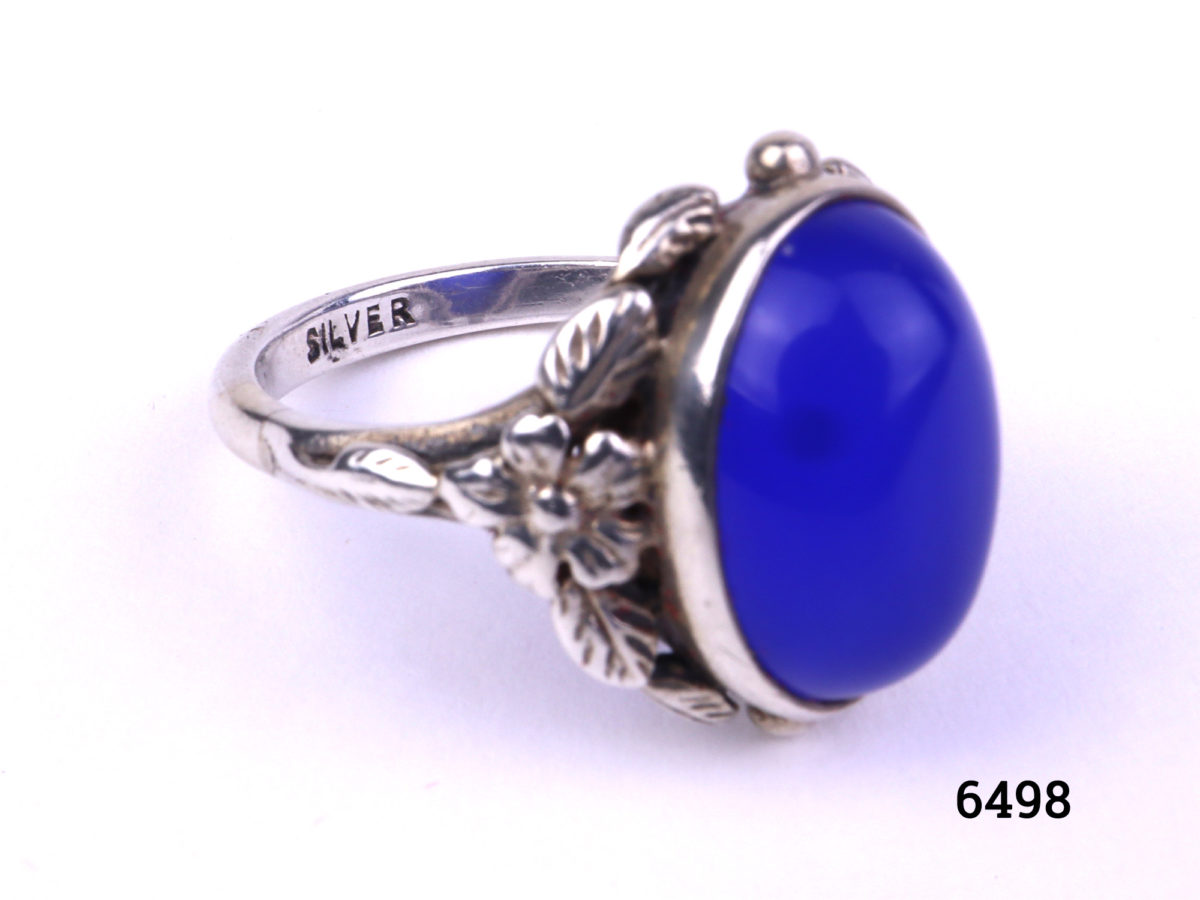 Arts & Crafts ring by Bernard Instone. Hallmarked silver ring set with bright sea blue oval chalcedony stone to centre and floral motifs to the shoulder either side. Size N / 6.5 Close up of the hallmark reading silver