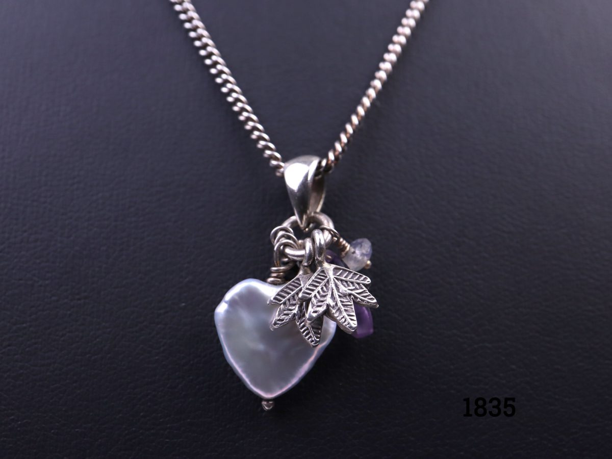 Azuni sterling silver necklace decorated with pearlised heart, leaves & crystal glass bead charms. Fully hallmarked c2006 London assayed Pendant drop length 30mm. Main photo showing necklace displayed on stand Close up of the charms on the pendant