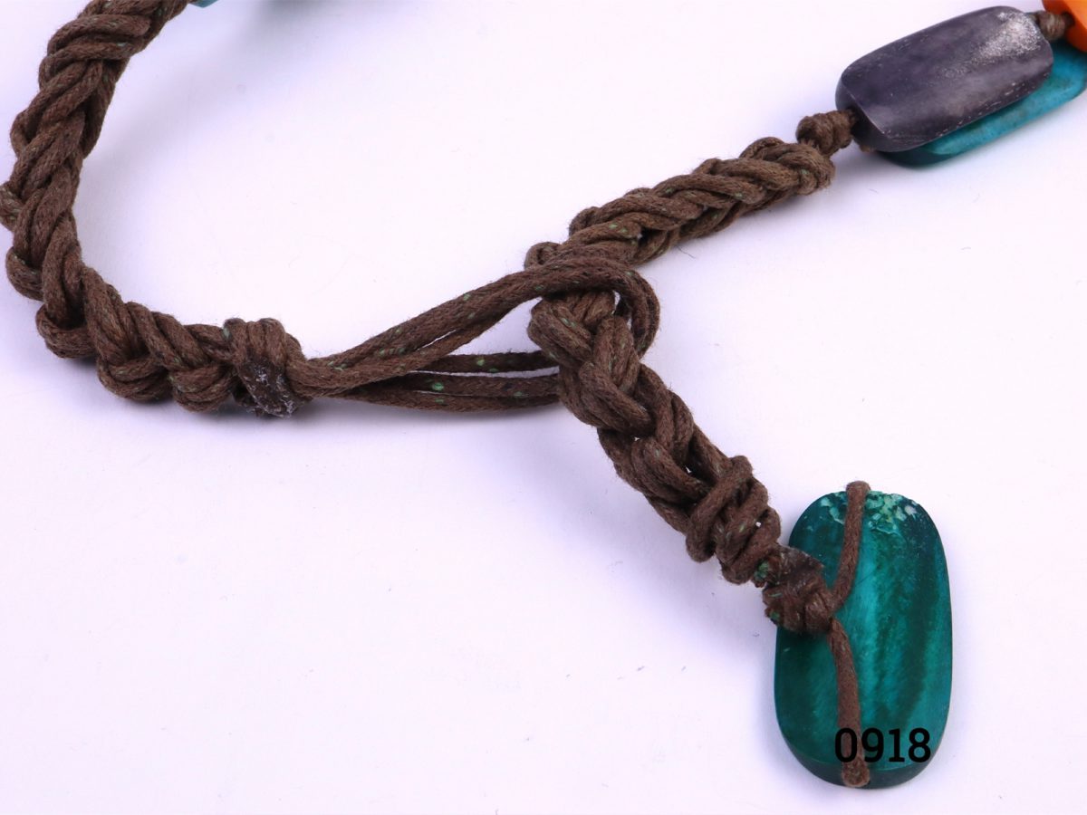 Colourful tagua nut necklace String bound multi-colour stained tagua nut bead statement necklace (Tagua is also known as vegetable ivory) Approximate bead size 40mm x 15mm Photo showing the the knot work of the string and fastening of small bead through a loop in the string