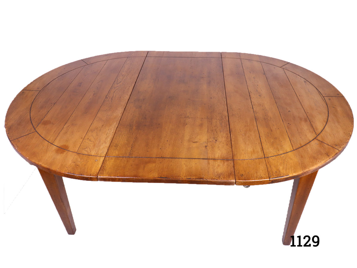 Extendable round oak table with 2 drop in leafs to extend from seating 4 to 10/12 people Unextended measurement 1190mm in diameter. Drop leaf measures 495mm by 1190mm x 2 Photo showing table with one drop leaf in place and seen from a raised angle