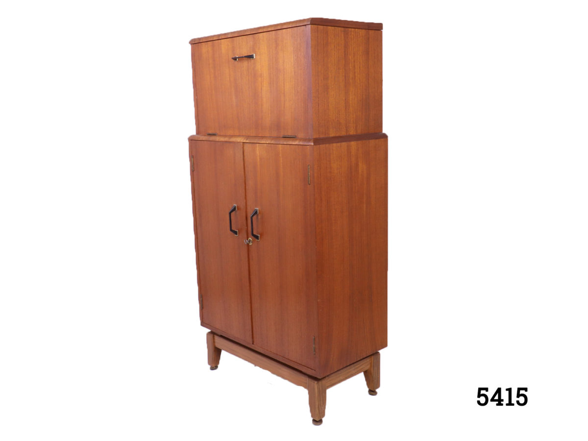 Retro Turnidge drinks cabinet 1960s-70s Retro drinks cabinet by London cabinet makers Turnidge in teak Mirror at back on the top with working lights (PAT tested) and lockable bottom section Top section measures 555mm wide by 305mm high Photo of closed cabinet seen from a side angle