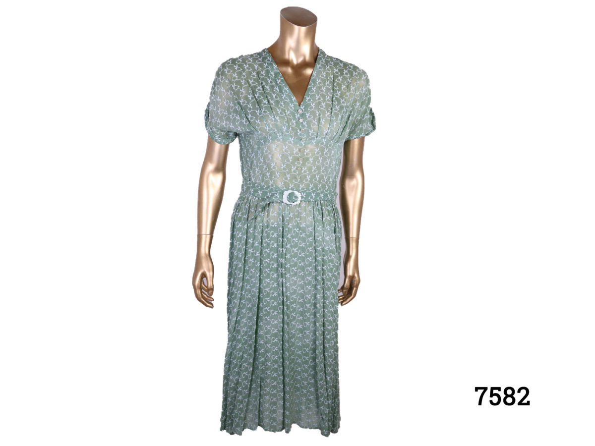Vintage 40s style green silk voile dress with embroidered pattern throughout. Side zip. Size: 10-12. Main photo of dress from front view displayed on a mannequin.