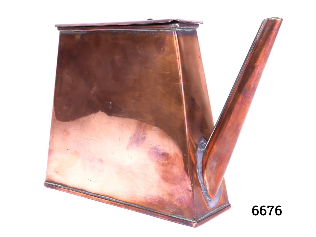 Antique copper watering can in an ingenious space saving shape with handle to the side Barge ware Photo at slight angle showing slim depth of can