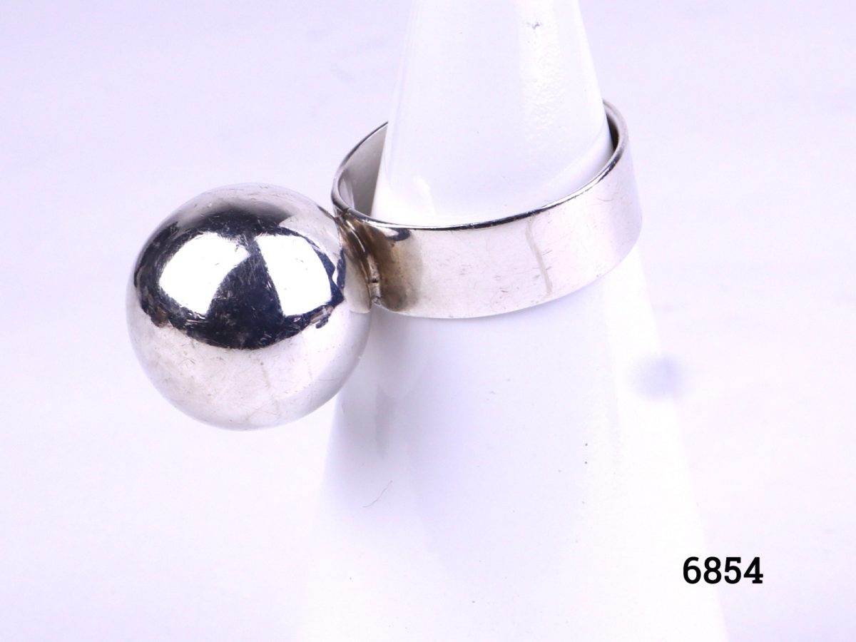 Modernist sterling silver ring with large silver ball Hallmarked 925 for sterling silver Size L / 5.75. Photo showing ring displayed on stand from a side angle