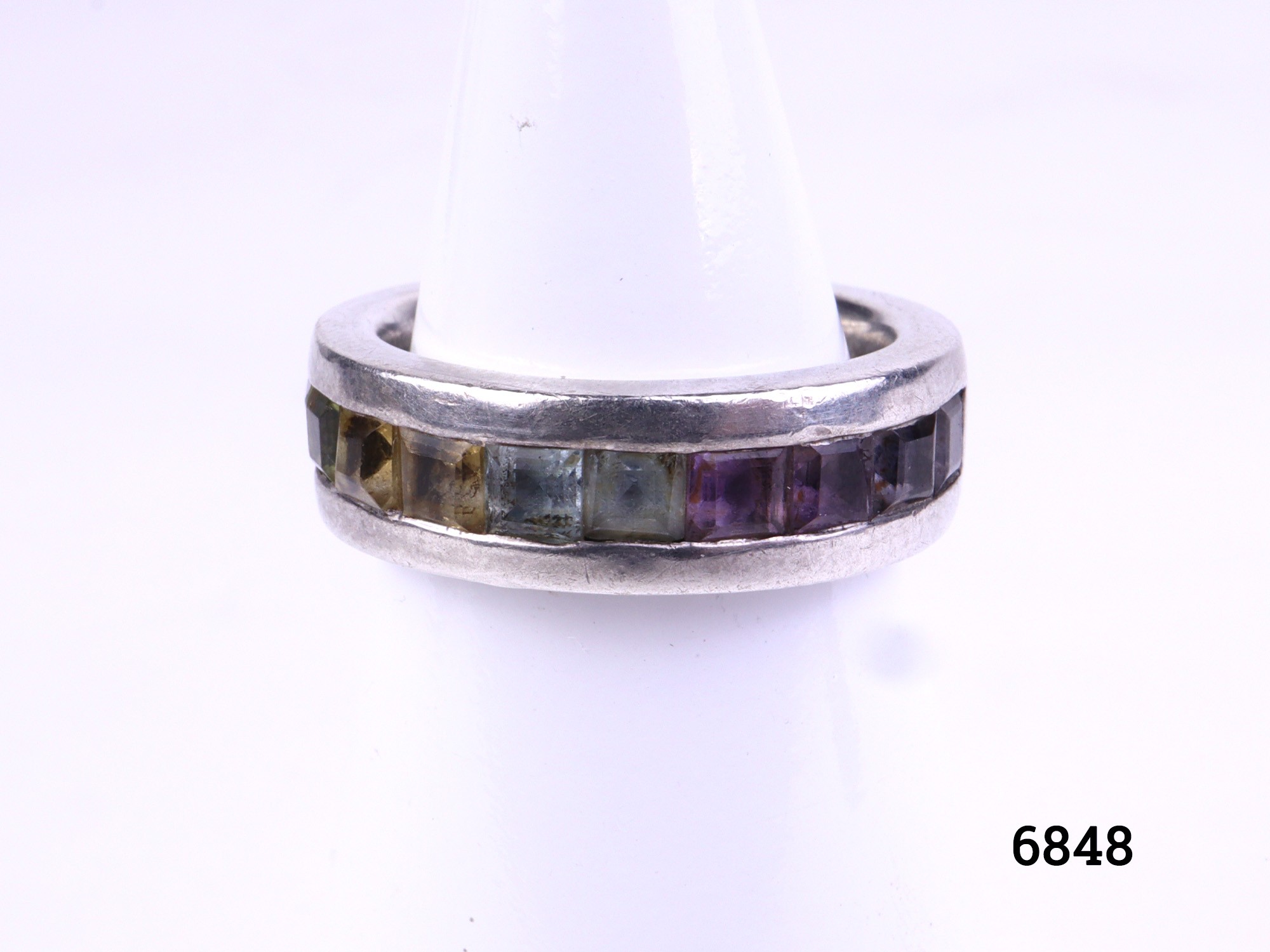 Sterling silver ring with row of rainbow coloured stones. Fully hallmarked for Birmingham assay. Size J / 4.75 Main photo of ring from the front displayed on stand