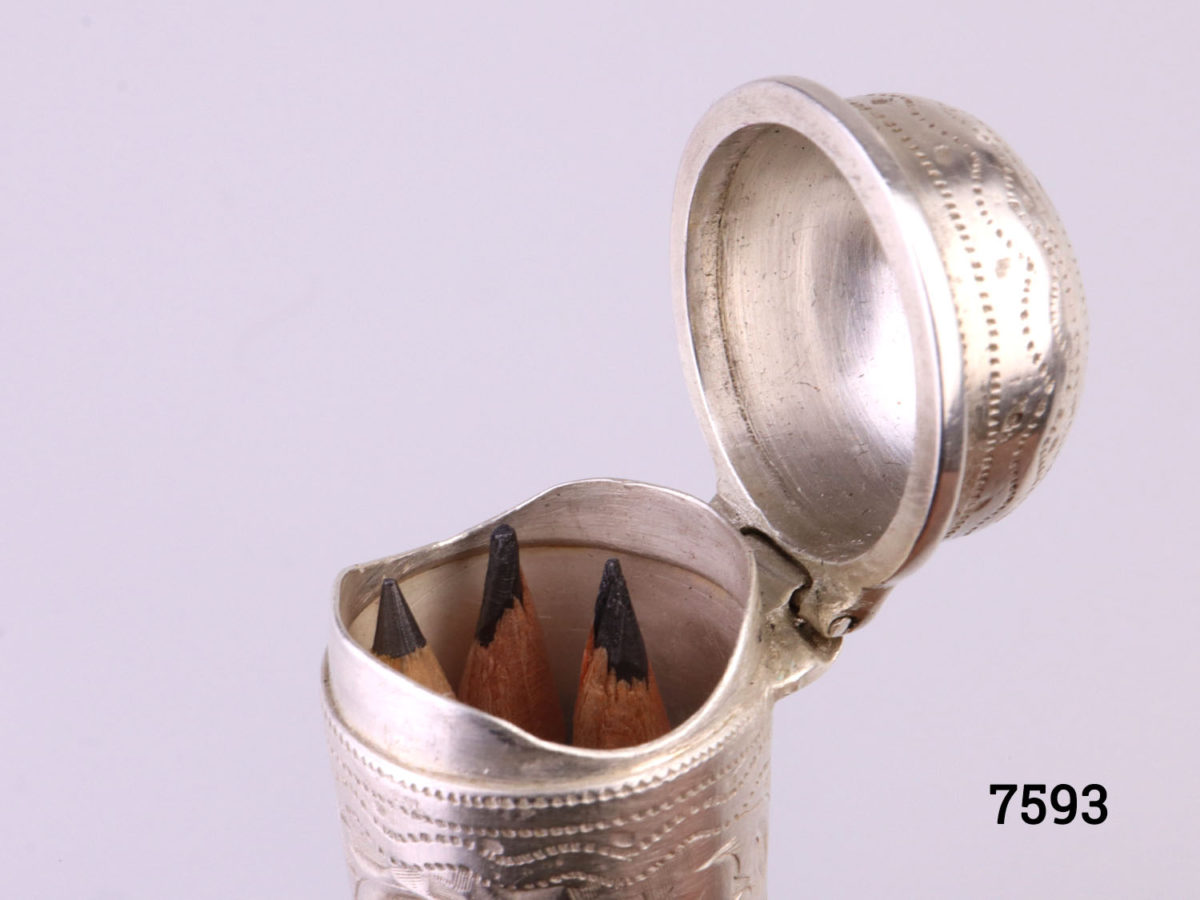 Antique Victorian sterling silver cheroot case with vacant cartouche for personalisation set in intricate scrollwork Hallmarked WN with a lion passant inside the lid (Currently housing small pencils) Close up photo of the top of cheroot with lid open