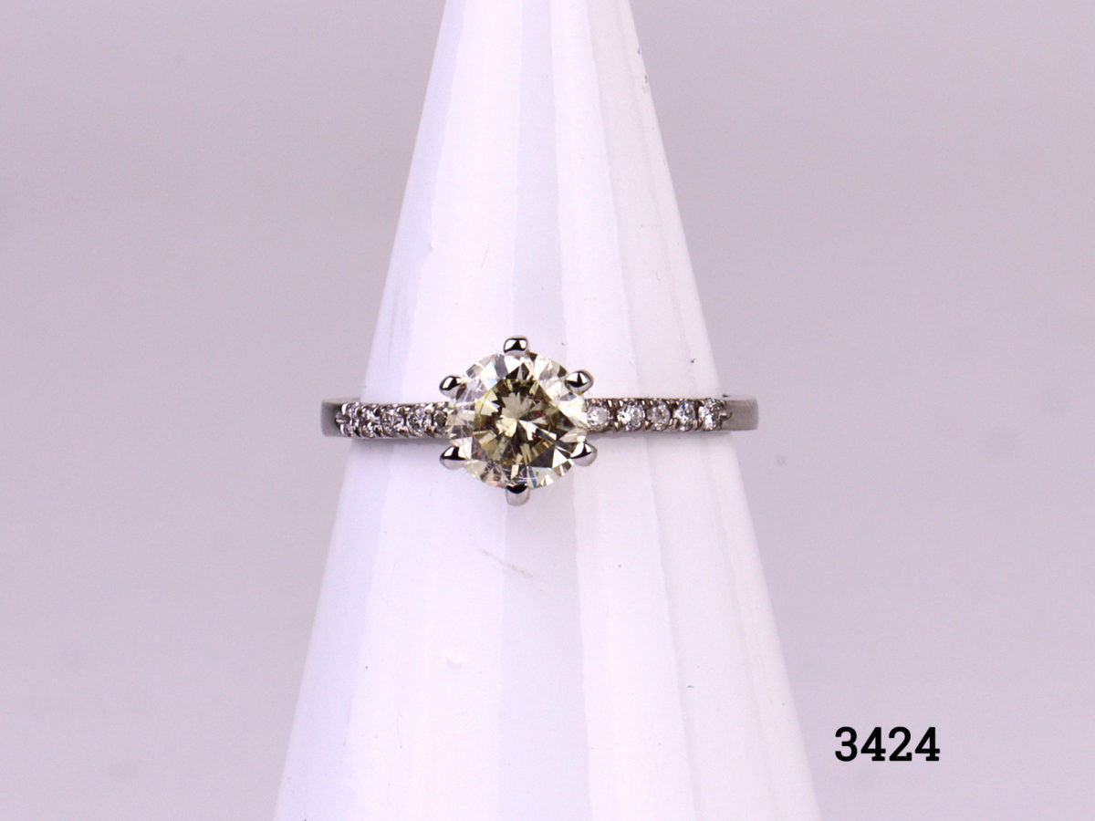 Vintage 1 carat round cut diamond set on new 14karat white gold ring with 12 small vintage diamonds set in the shoulders (6 to each shoulder). SI1 clarity diamond with E to F colour. Gemological Institute of Europe (G.I.E) certified. Box included. Size L.5 / 6 Weight 1.8 grammes Main photo of ring displayed on stand from full front view