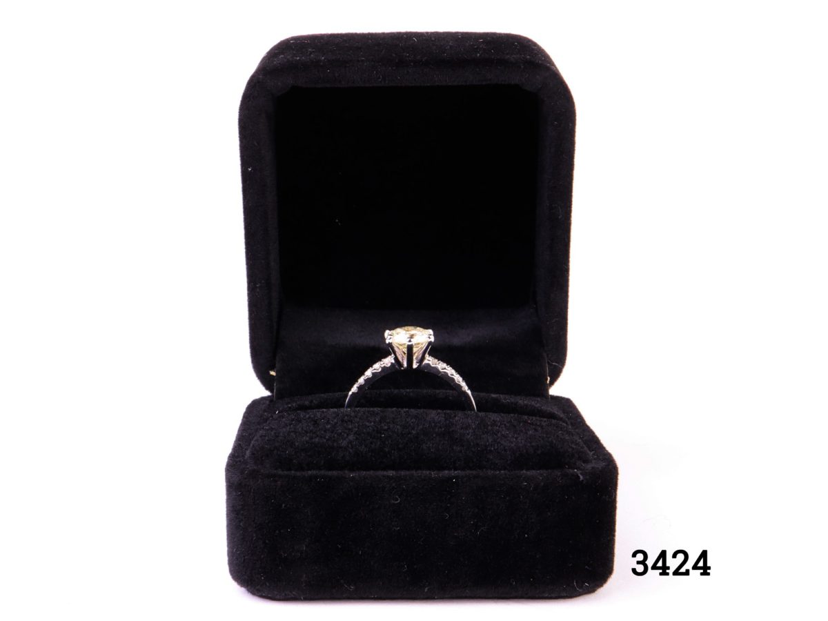 Vintage 1 carat round cut diamond set on new 14karat white gold ring with 12 small vintage diamonds set in the shoulders (6 to each shoulder). SI1 clarity diamond with E to F colour. Gemological Institute of Europe (G.I.E) certified. Box included. Size L.5 / 6 Weight 1.8 grammes Photo of ring in the box with the central diamond set within the prongs