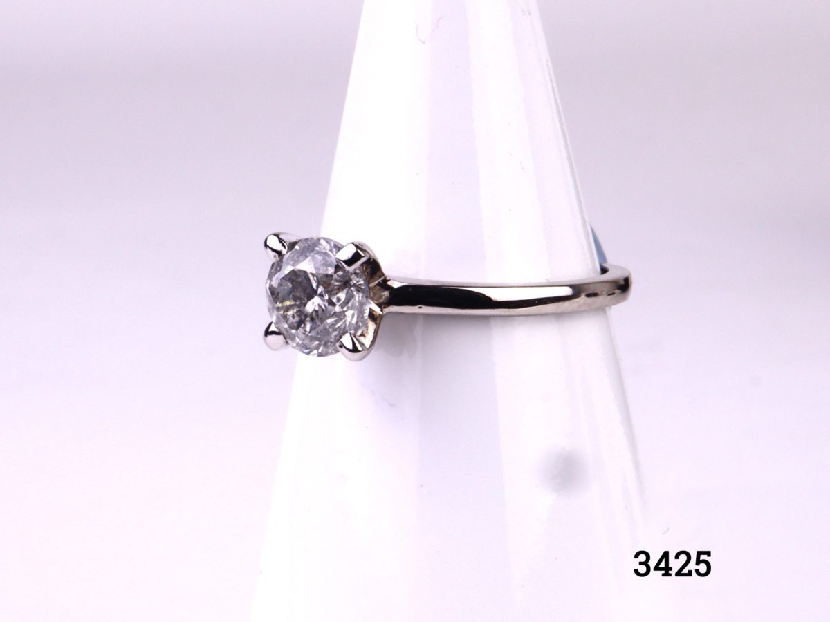 Vintage round brilliant cut 1.2 carat diamond solitaire reset modern onto 14kt white gold ring. SI1 clarity diamond with E colour. Box included. Size M.5 / 6.5. Weight 2.6g Side view of ring displayed on stand