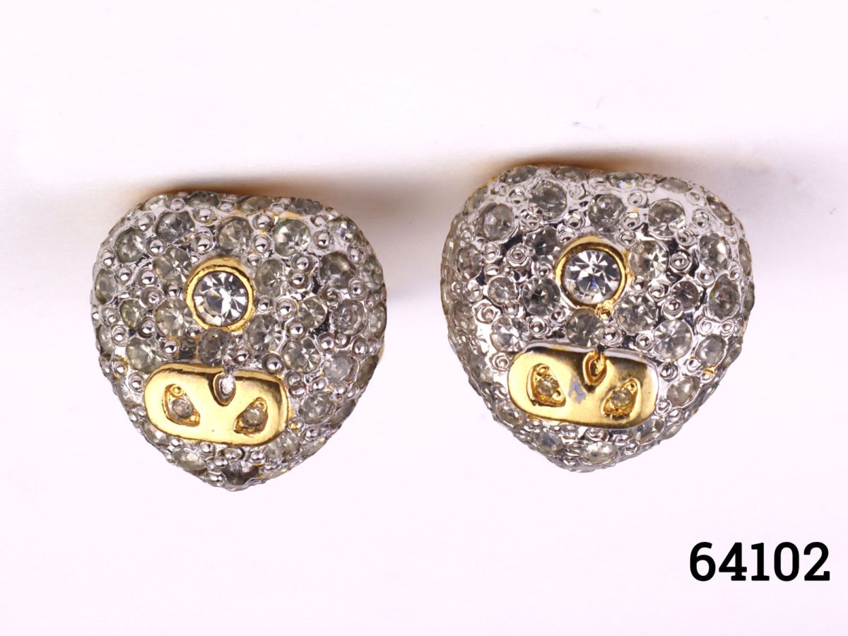 Vintage clip-on earrings by Valentino. Heart shaped earrings encrusted with clear crystals with a gilt accent. Signed Valentino to the back. Both clips in good working order. Earrings weigh 10.9 grammes Main photos of both earrings side by side front facing
