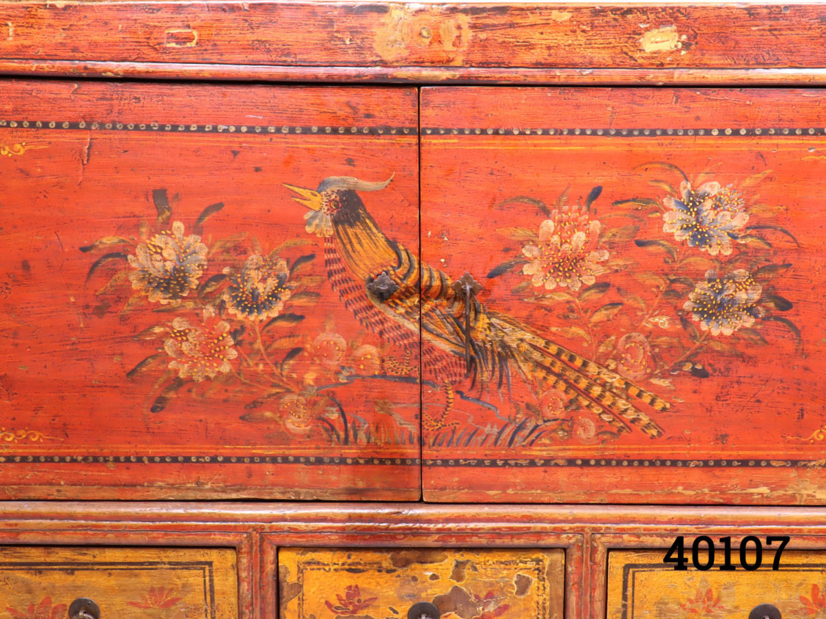 19th Century red lacquered country house Chinese cabinet / side board. 2 central opening doors at top with inner shelf and 3 small drawers at the bottom. Some signs of wear. Close up photo of bird and floral decoration on the doors.