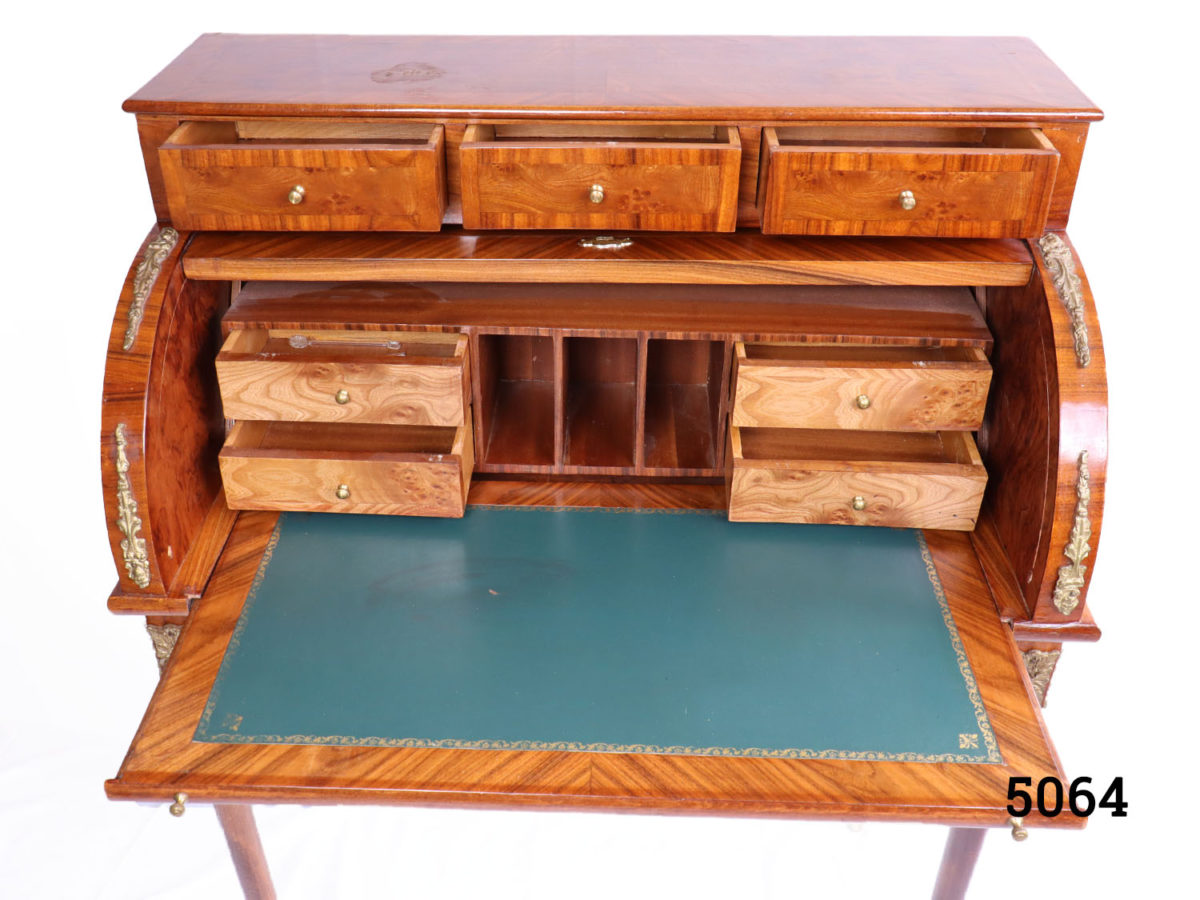 20th Century French roll top bureau decorated throughout with ormolu. Decorative key only. Photo of roll top and all small drawers open and writing surface pulled out looking straight on