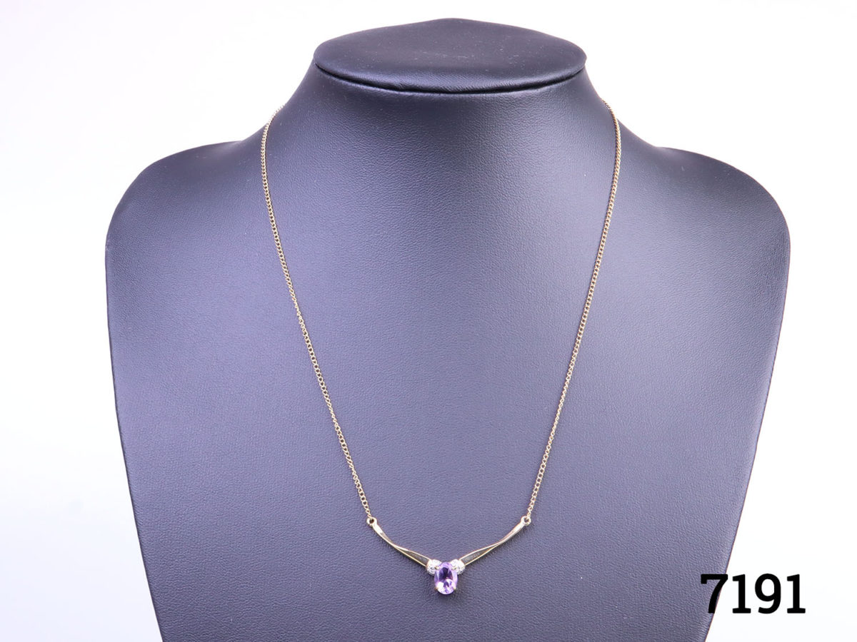 9 karat gold necklace with attached 9 karat gold and oval cut amethyst and diamond pendant. Pendant measures 40mm wide Main photo showing necklace displayed on stand