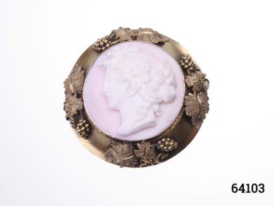 Victorian carved pink conch shell cameo of a lady in rare ornate mount decorated with grapes and vines in original box. Not hallmarked but tests for 18karat gold. Weighs 13.8 grams and measures 43mm in diameter Main photo showing brooch front seen straight on