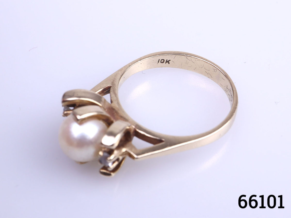 Vintage 10 karat gold courtship ring with pearl and diamonds. Size K / 5.25 Weight 3.6g Photo of ring on a flat surface from a raised slightly angled view with 10k hallmark visible